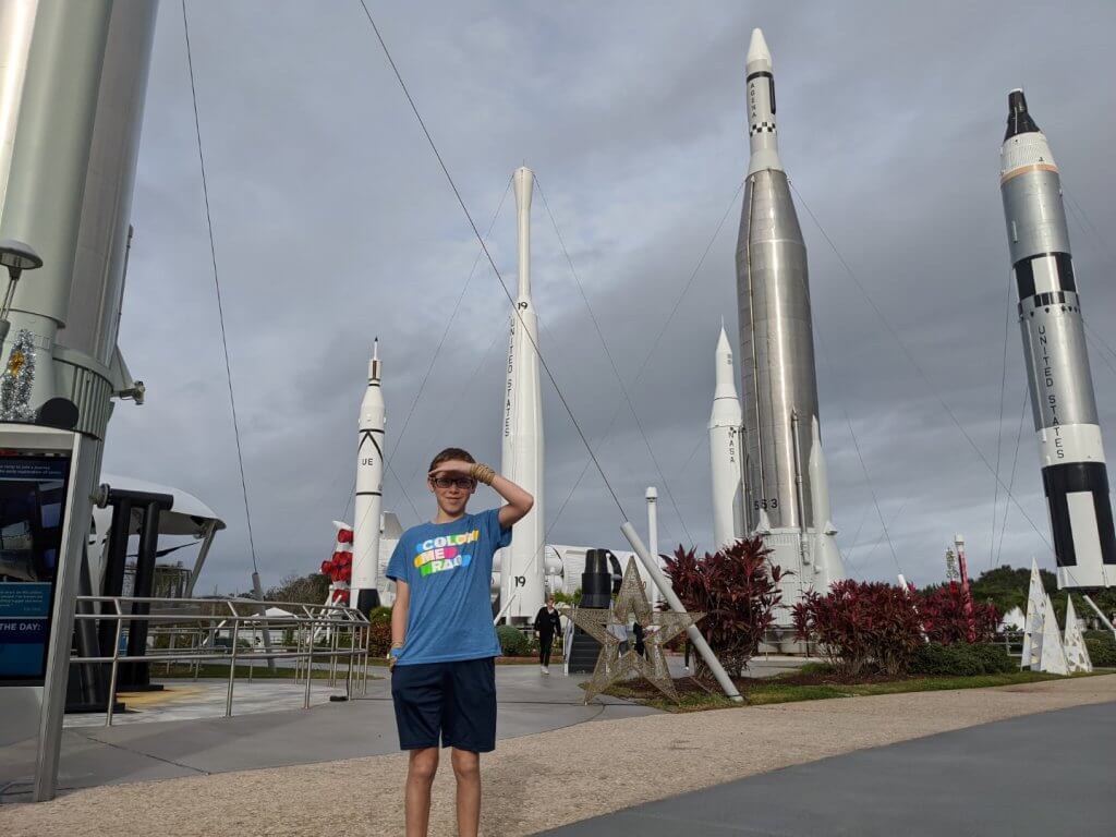 boy in front of several rockets