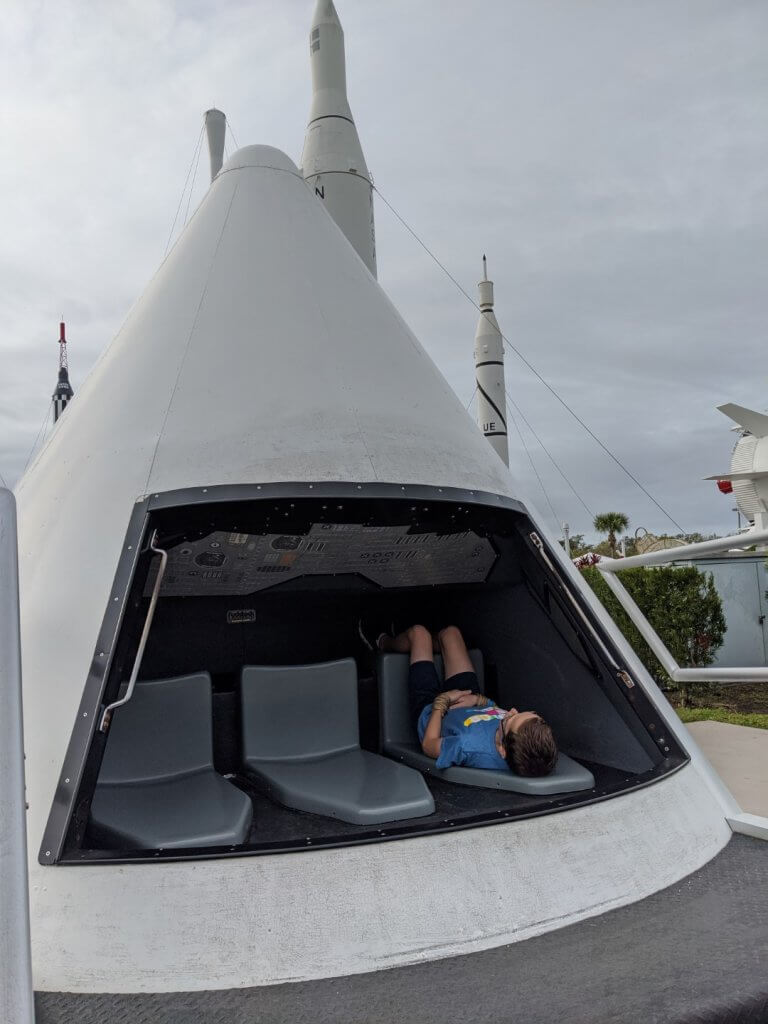 boy sitting in a model rocket