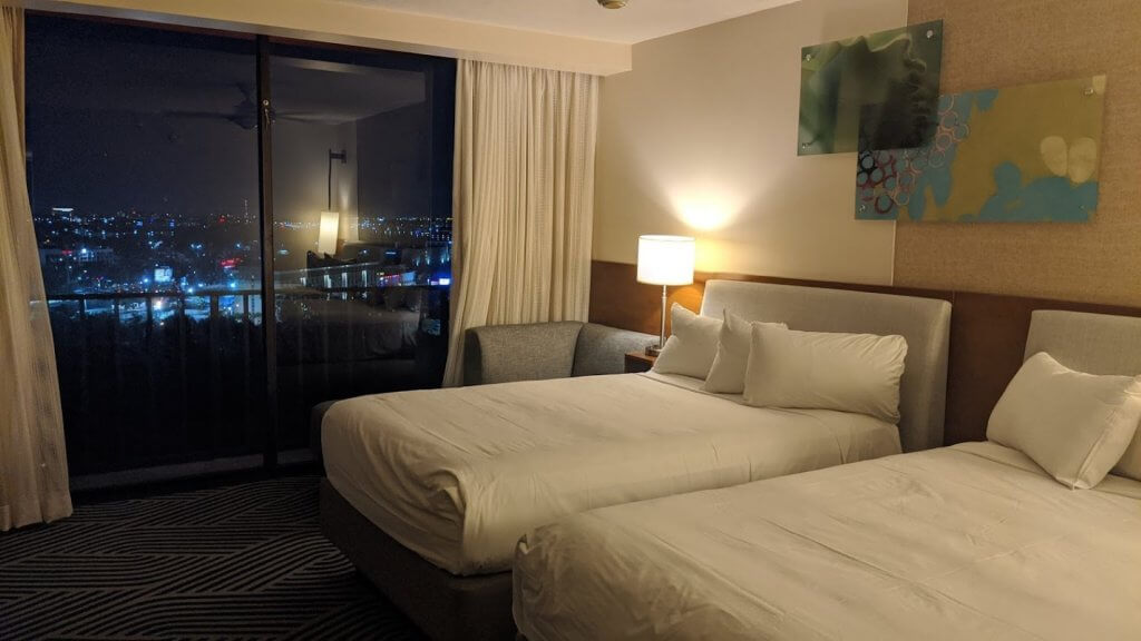 hotel room with two beds and view of city