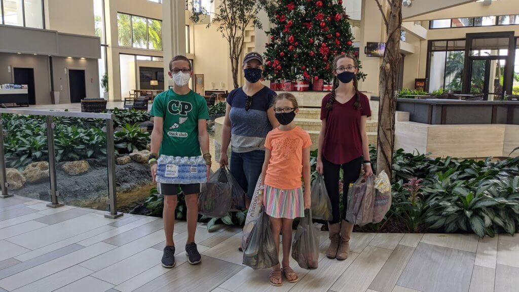 family with masks and grocery bags