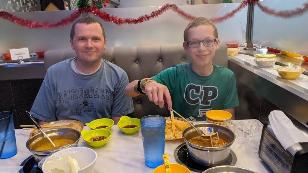 father and son eating at restaurant