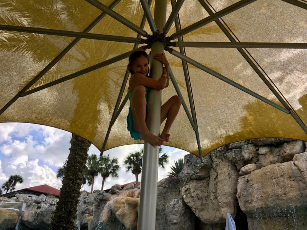 girl climbing shade umbrella