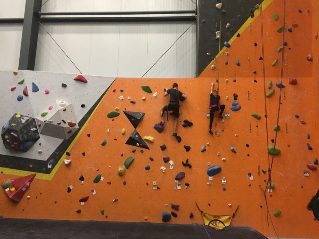 boy and girl on orange climbing wall