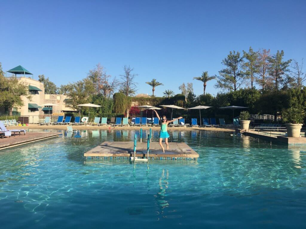 girl jumping into swimming pool