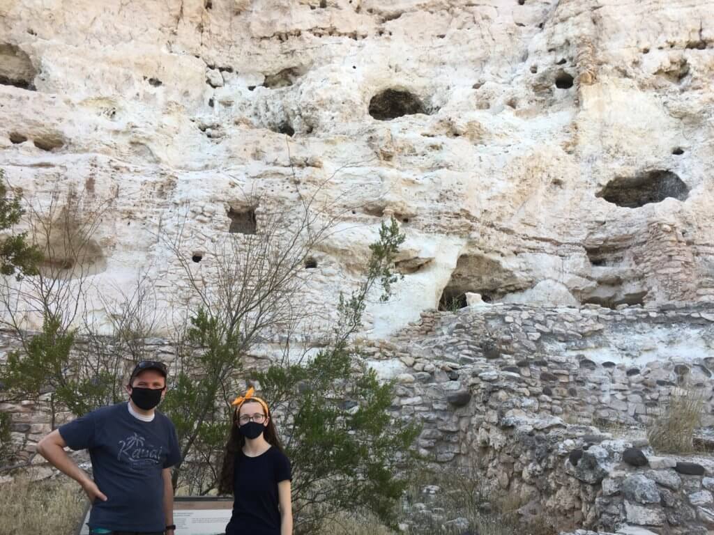 father and daughter in face masks in front of rock wall