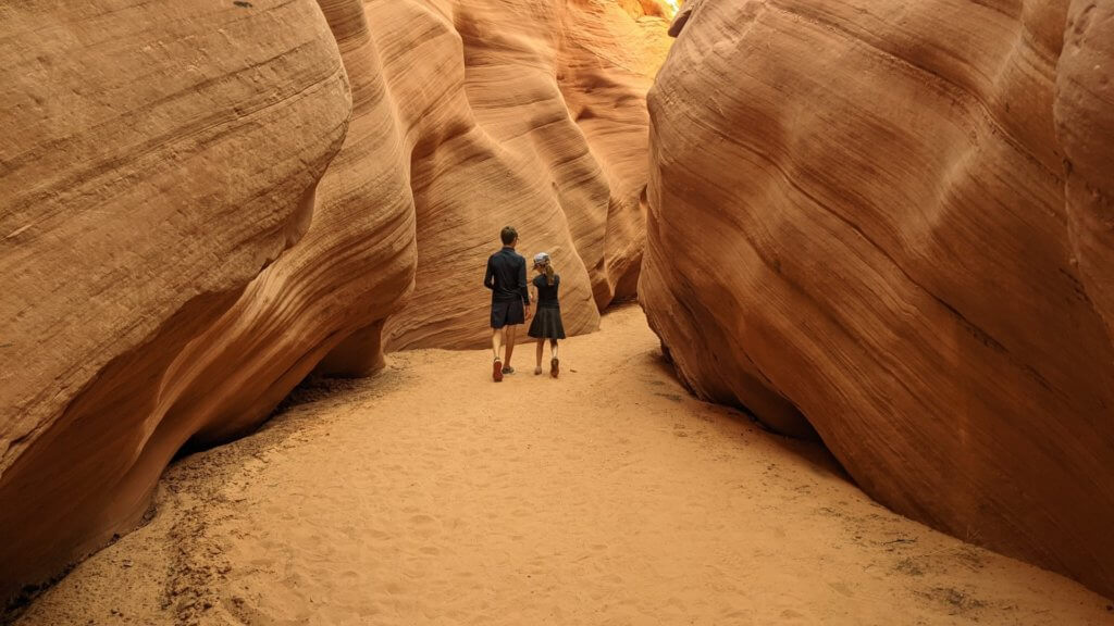 girl and boy walking in narrow canyon