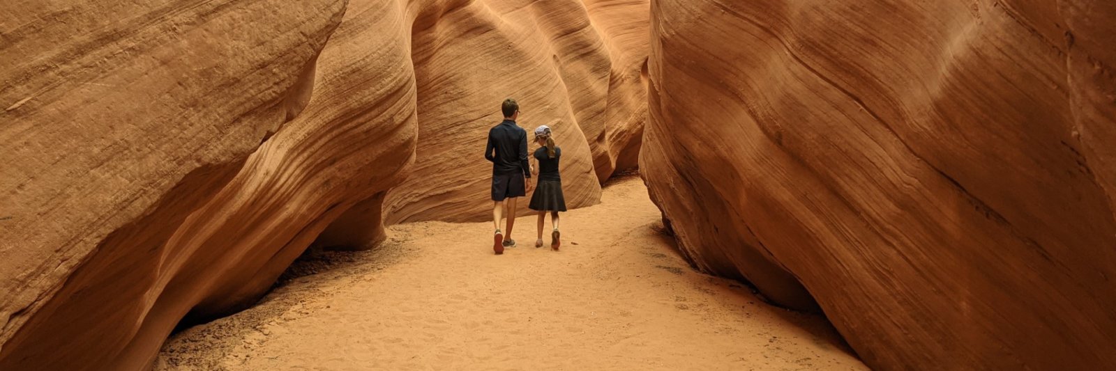 girl and boy walking in narrow canyon