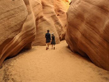 girl and boy walking in narrow canyon