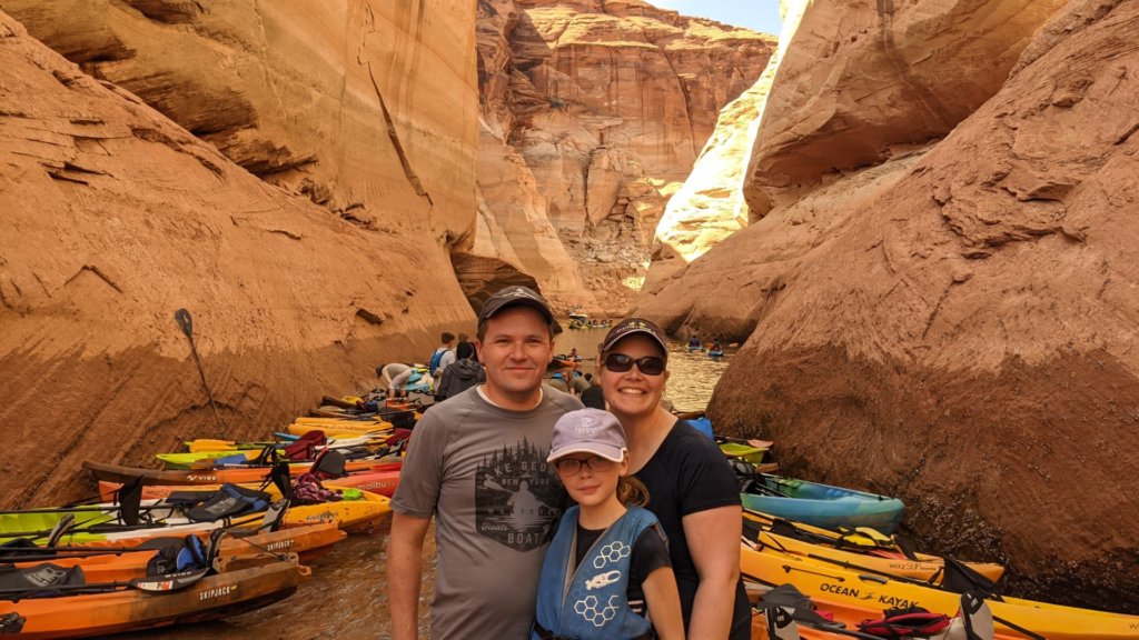 people in front of kayaks in a canyon