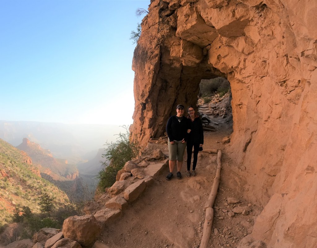 woman and daughter in front of tunnel over trail