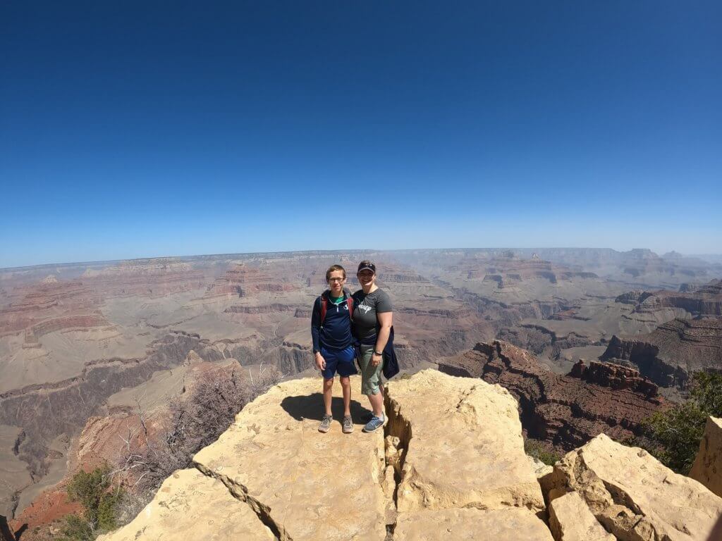 woman and boy on rock in front of canyon