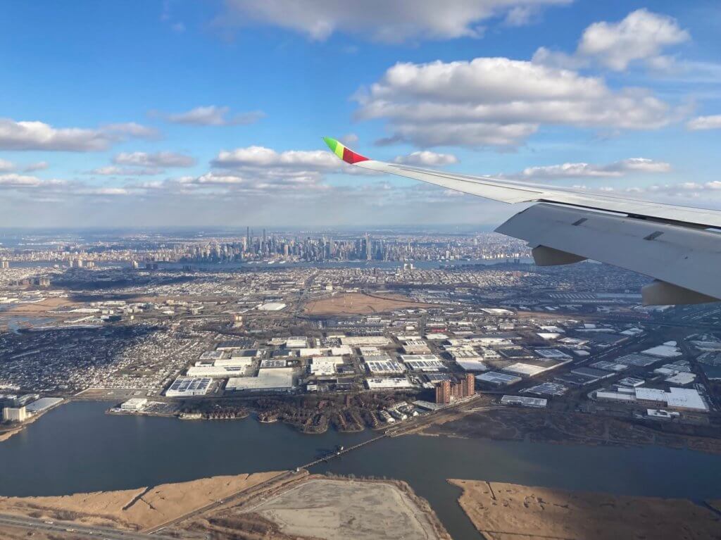 airplane wing over a city with river