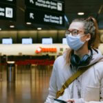 girl with mask and headphones in airport