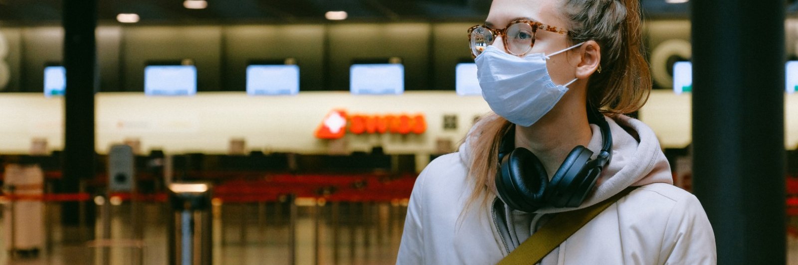 girl with mask and headphones in airport