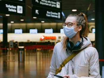 girl with mask and headphones in airport