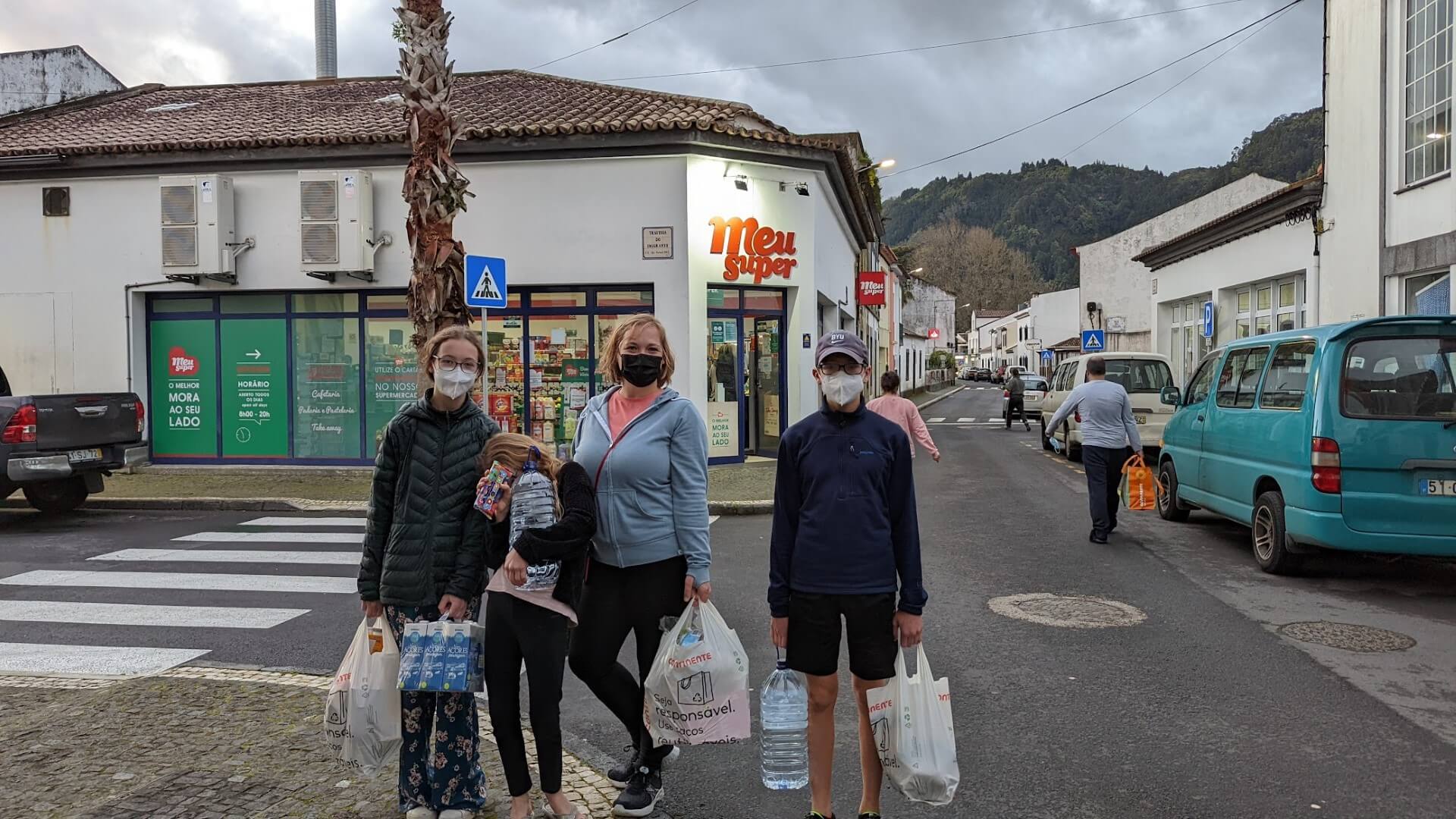family with masks and grocery bags