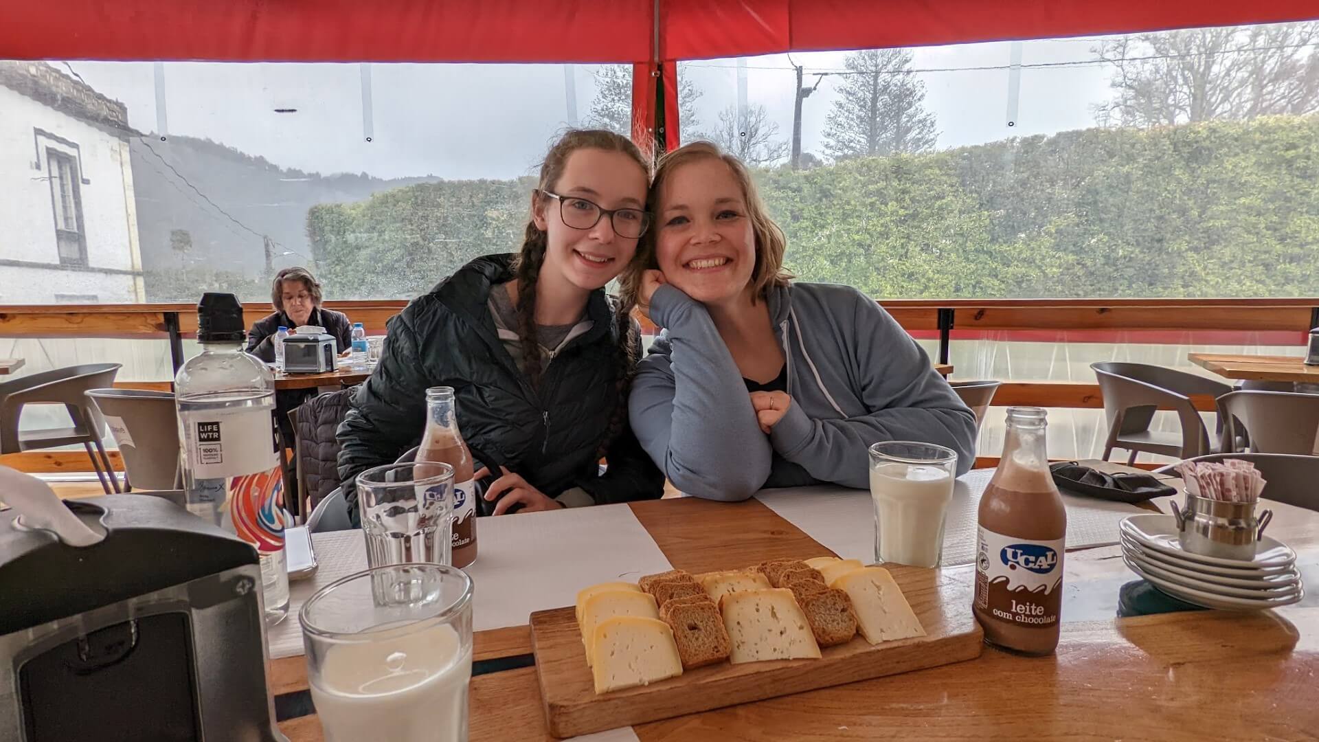 woman and daughter at table with cheese plate